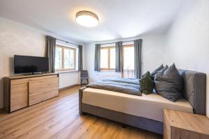 a bedroom with a bed and a flat screen tv at Schusterhäusl in Rauris