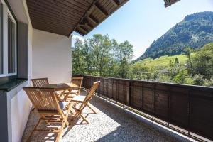 a patio with two chairs and a table on a balcony at Schusterhäusl in Rauris