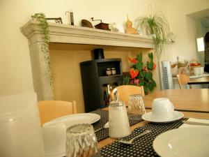 a dining room table with a fireplace in a kitchen at Garni Rosa Delle Alpi in Gordola