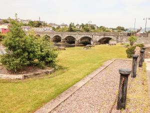 a stone bridge over a grassy field next to a river at Shamrock House in Killorglin