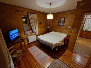 a bedroom with a bed and a desk and a television at Appartamento Lorena in Rocca Pietore