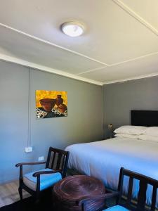 a bedroom with a bed and two chairs and a table at Lavender farm home in Port St. Johns