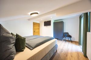 a bedroom with a bed and a chair in it at Schusterhäusl in Rauris
