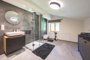 a bathroom with a sink and a glass shower at Schusterhäusl in Rauris +32 photos