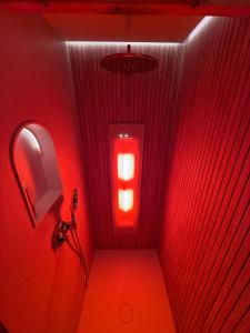 a red corridor with a red light in a bathroom at Sfeervol Tiny House met luxe jacuzzi & tuinkamer in Heerenveen