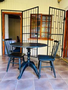a black table and two chairs in a room at Lavender farm home in Port St. Johns