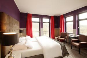a bedroom with a white bed and red curtains at Schloss Basthorst in Crivitz +56 photos