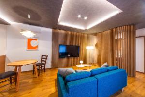 a living room with a blue couch and a table at MONTIS HOTEL Hida Takayama in Takayama