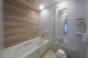 a white bathroom with a tub and a sink at MONTIS HOTEL Hida Takayama in Takayama +10 photos