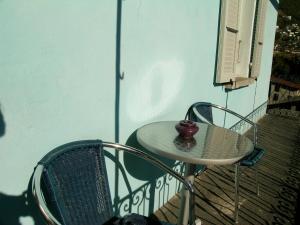 a small table and a chair on a balcony at Garni Rosa Delle Alpi in Gordola +27 photos
