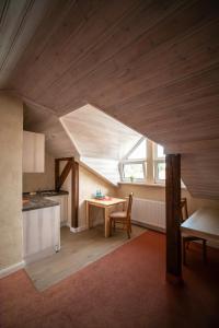 an attic kitchen with a table and a window at Hotel-Restaurant Alter Krug Kallinchen in Kallinchen