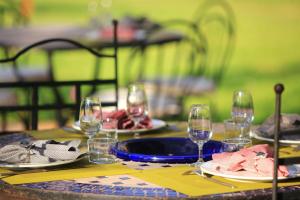 a table with plates and wine glasses on it at La Maison d'Anais in Vic-en-Bigorre