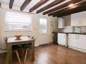 a kitchen with a table and chairs and a window at Chandlers Cottage in Conwy