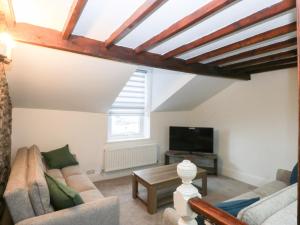 a living room with a couch and a tv at Chandlers Cottage in Conwy