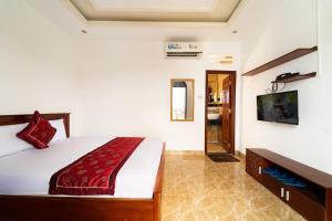 a bedroom with a bed and a flat screen tv at Collection O Long Phung Hotel in Ho Chi Minh City +22 photos