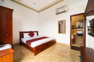 a bedroom with a bed and a bathroom with a sink at Collection O Long Phung Hotel in Ho Chi Minh City