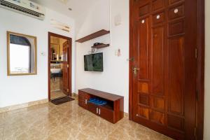 a hallway with a wooden door and a room with a mirror at Collection O Long Phung Hotel in Ho Chi Minh City