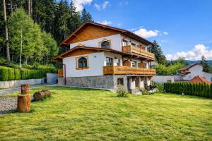 a house with a large yard in front of it at Vila Belcin Spa&Retreat in Buşteni