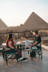 a group of people sitting at a table in front of the pyramids at Voyage On The Spot in Cairo