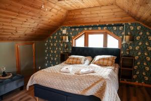 a bedroom with a bed in a room with wooden ceilings at Villa Granliden in Ludvigsborg