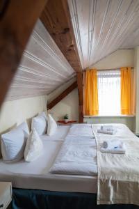 a large white bed in a room with a window at Hotel-Restaurant Alter Krug Kallinchen in Kallinchen