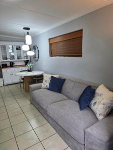 a living room with a couch and a kitchen at Roux Casa 2 in Swellendam