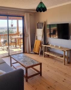 a living room with a tv and a table at The Lekker Plek - Private country cottage in Zuurbraak