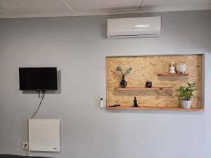 a wall with a tv and shelves on a wall at Roux Casa 2 in Swellendam
