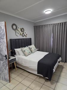 a bedroom with a bed with a black and white comforter at Roux Casa 2 in Swellendam
