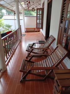 two wooden chairs sitting on the porch of a house at Social Stay Hostal in Ahangama