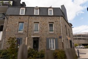 an old brick building with a black roof at 201- Appartement- proche gare in Saint-Brieuc