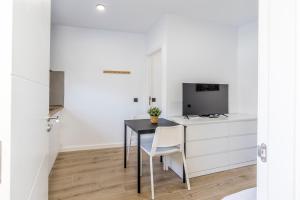 a small kitchen with a black table and white cabinets at Charming Street Studio in Tegueste in Santa Cruz de Tenerife +6 photos