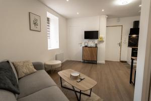 a living room with a couch and a table at 201- Appartement- proche gare in Saint-Brieuc