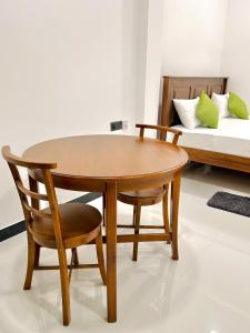 a wooden table and chair in a room with a bed at Rufero Transit Hotel in Katunayaka