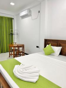 a white bed with a towel on top of it at Rufero Transit Hotel in Katunayaka +24 photos