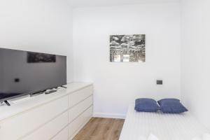 a white living room with a couch and a tv at Charming Street Studio in Tegueste in Santa Cruz de Tenerife