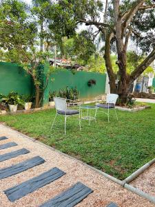 two chairs and a table in the grass at Rufero Transit Hotel in Katunayaka