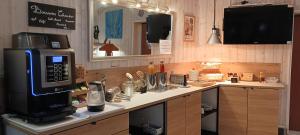 a kitchen with a counter with a microwave on it at Hôtel Le P'tit Monde in Montignac