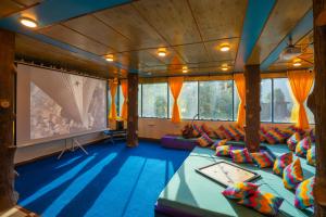 a large room with couches and a projection screen at goSTOPS Kasol in Kasol