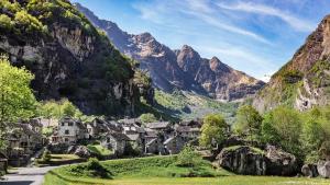 a village in a valley in the mountains at Garni Rosa Delle Alpi in Gordola