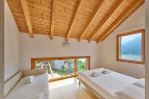 a bedroom with two beds and a large window at Paradiso del lago in Bellano