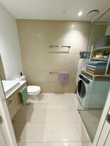 a white bathroom with a toilet and a sink at CBD Apartment, Sleeps 4 with Free Car Park in Melbourne +27 photos