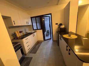 a kitchen with white cabinets and a table in it at Safari Cozy Homes in Nairobi