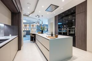 a kitchen with a white counter top and wooden cabinets at Luxurious subterranean mansion - 3 spectacular bedrooms in Altrincham