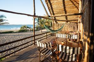 a restaurant with a table and chairs on the beach at Tofo Beach Gardens in Inhambane