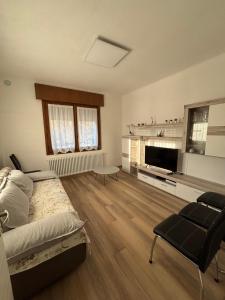 a bedroom with a bed and a living room at MARGHERITA'S Guest House in Tarzo