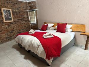a bedroom with a large bed with a red blanket at Witgatboom Boskamp in Naboomspruit +35 photos