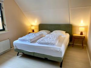 a bedroom with a bed with two pillows on it at Buitenplaats 67 with optional sauna in Callantsoog