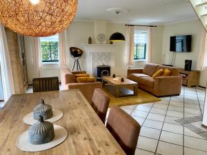 a living room with a table and chairs and a living room at Buitenplaats 67 with optional sauna in Callantsoog