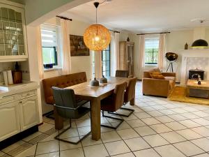 a kitchen and dining room with a table and chairs at Buitenplaats 67 with optional sauna in Callantsoog